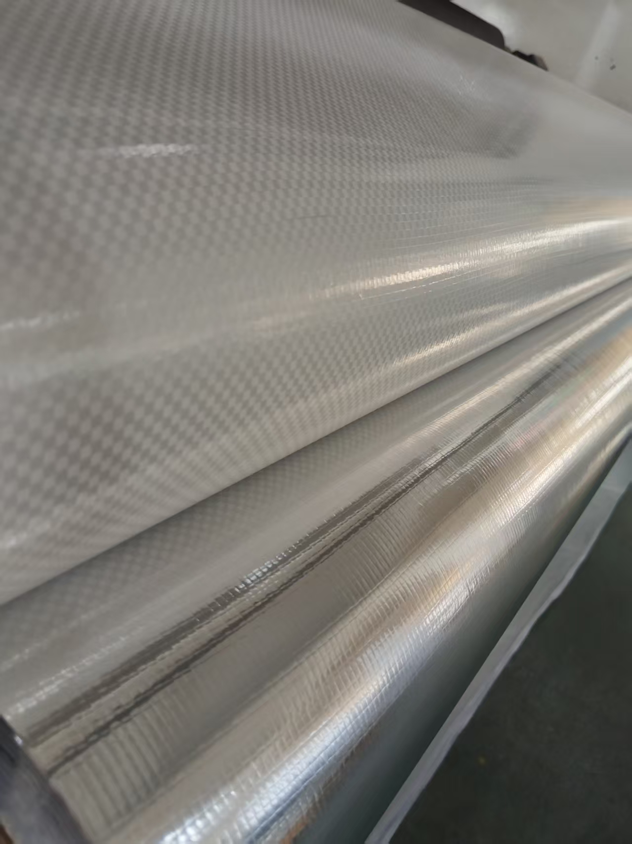 Reflective silver VMPET laminate roll with a visible woven texture.