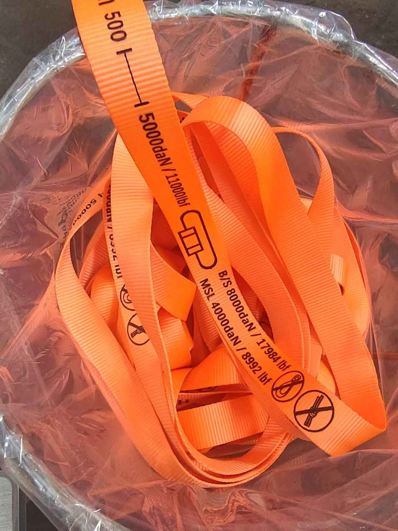 Orange woven polyester lashing straps with printed strength markings.